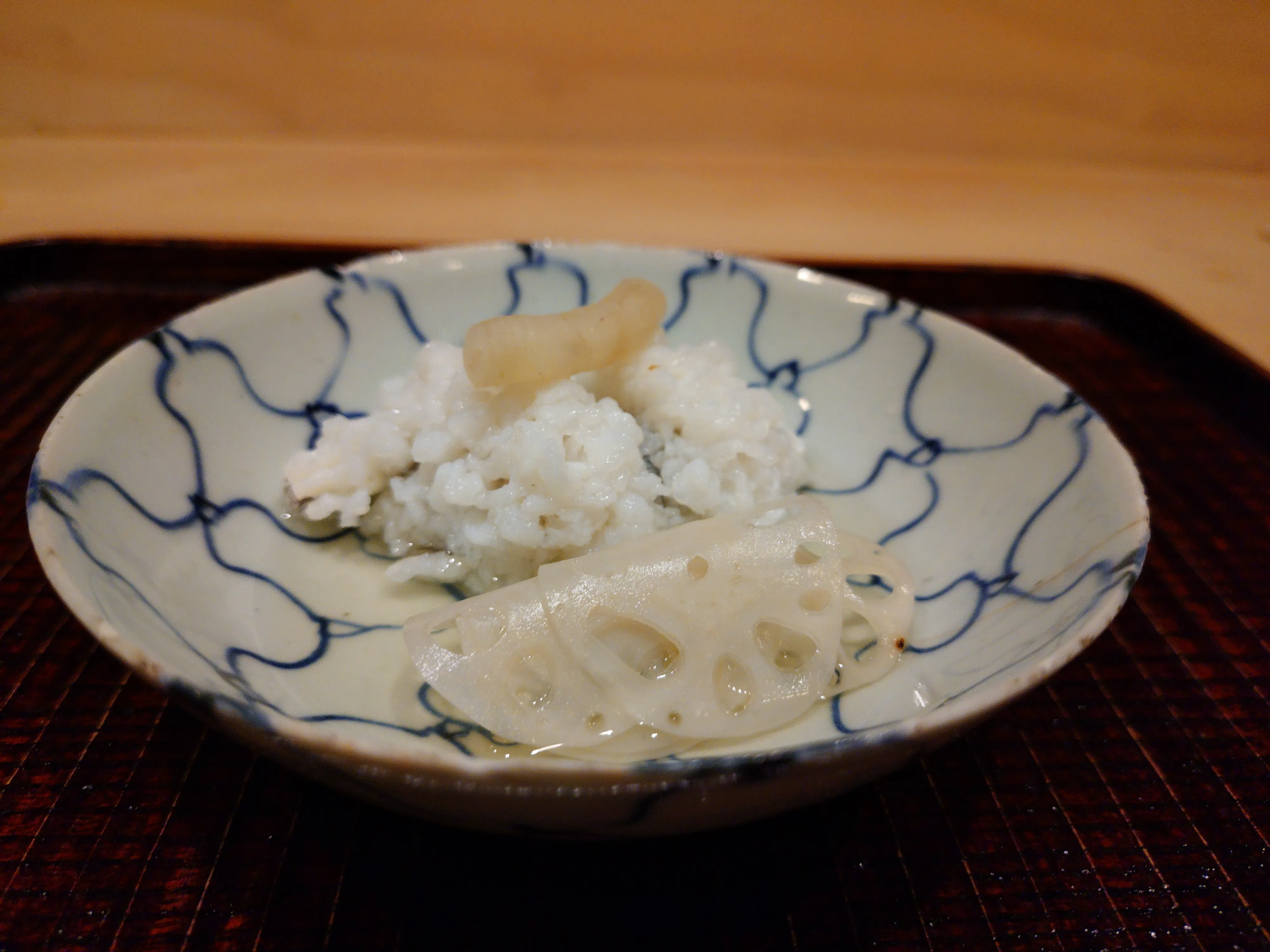 蓮根と粥のような一皿を盛った染付の鉢